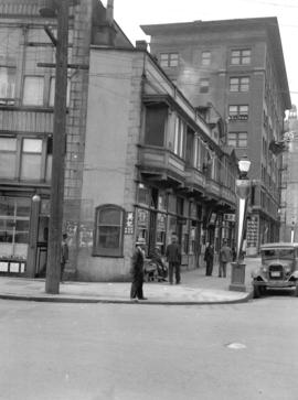 [View of corner of shallow building at Pender and Carrall Streets]