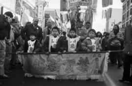 Children carrying a banner in a parade on Pender Street in Vancouver Chinatown
