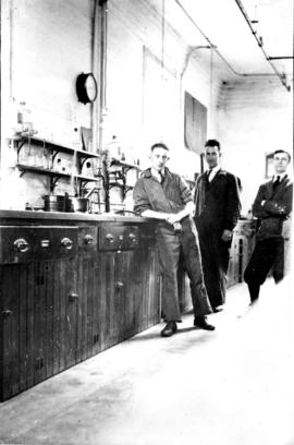 Three laboratory workers: E.F. Shoove, D. Morris, and G. Stevens