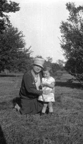 [Woman outdoors with young child]