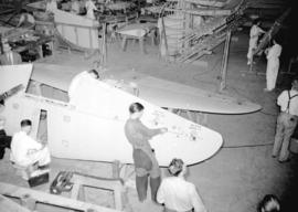 [Men and women constructing airplanes at the Boeing aircraft plant on Georgia Street]