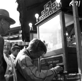 Boy playing with coin-operated Digger arcade game