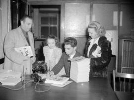 [Columnist Jack Scott signing copies of "Our Town"]
