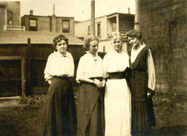 [Winifred Mabel Pierce standing in yard with three women]