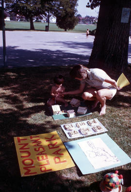 [Woman and child making crafts with popsicle sticks in Mount Pleasant Park]