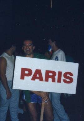 Man holding 'Paris' sign