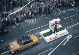 43rd Grey Cup Parade, on Granville Street Rover Scouts float and car, ticker tape, and spectators