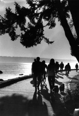 Strollers and cyclists during sunset on Stanley Park Seawall