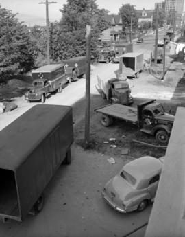 [Red Cross delivery trucks in a city neighbourhood]