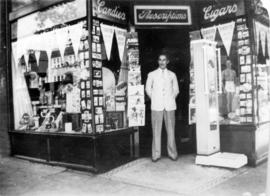 [Unidentified man standing in front of one of the Vancouver Drug Company stores]
