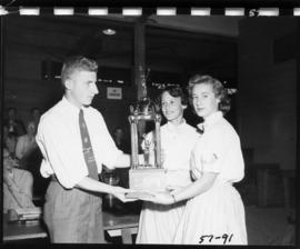 Girls receive trophy in 1957 P.N.E. 4-H and Future Farmers of Canada competition