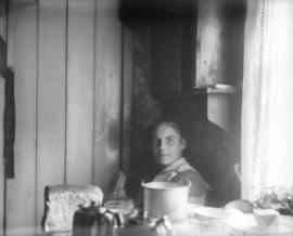 A woman seated at a table covered in dishes