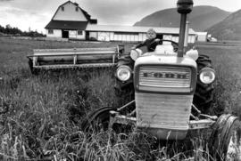 Boy driving threshing machine on Fraser Valley farm