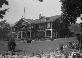 Building with a stone fence in front, possibly Bowen Island Lodge