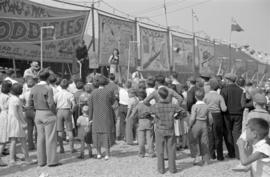 [Crowd in front of sideshow attraction]