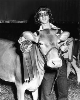 1977 P.N.E. 4-H Club competition winner poses with livestock and prizes