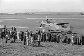 [A crowd looking at two airplanes]