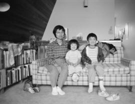 Woman and two young children on a couch