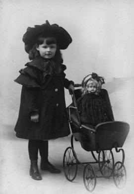 Portrait of Olga Jenkinson Bell as a child with doll carriage