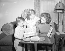 Mrs. Gordon Egart and children [looking at Victory Bonds]