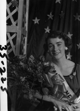 Portrait of Nancy Hansen, Miss P.N.E. 1954, posing with trophy and flowers