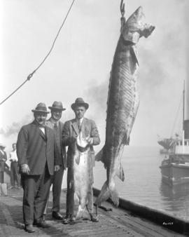 [Mr. Hagar, Mr. Eckman, and Mr. Winch with a 700 pound sturgeon and a salmon on the Canadian Fish...