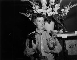 Woman holding two Chihuahuas at 1955 P.N.E. Dog Show