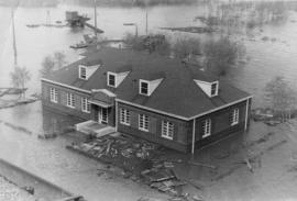 Building surrounded by flood waters and debris