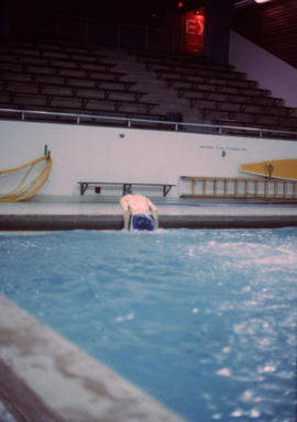 [Boy leaning out of swimming pool]