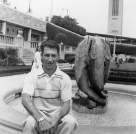 [Joseph Selsey seated on Fish Fountain in Oakes Garden Theatre, Niagara Falls]