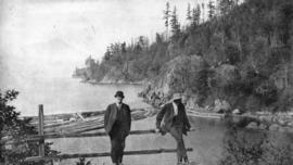 [Two men near forested shore]