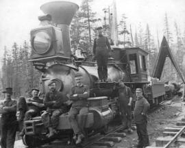 [Group of men with railway engine pulling logs]
