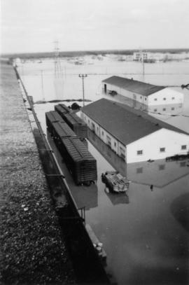 Flood waters surrounding buildings and train cars