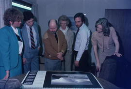 Toni Onley (centre) and group examine his Centennial Art Series print at Agency Press