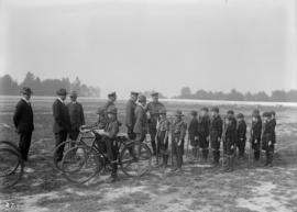 Military officers inspecting scouts, some pushing bicycles