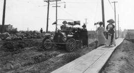 [A car on unpaved Maple Street and Maud Boscawen Matthews and friend]