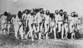 [Group of nude Doukhobor men, women, and children on a dirt road]