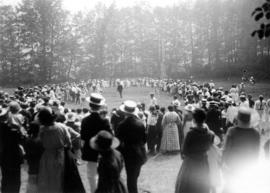 [Crowd lining a field to watch a sporting activity]