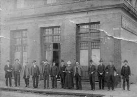 [A group of people standing in front of Oppenheimer Bros. Wholesale Grocers building at Powell St...