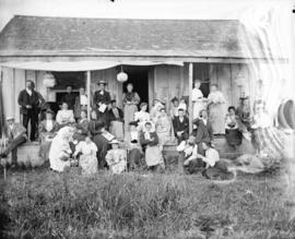 [Men and women assembled on porch of Linn's cottage]