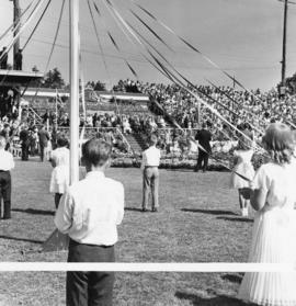 [Children prepare to dance around a 'may pole' for H.R.H. Queen Elizabeth and H.R.H. The Prince P...