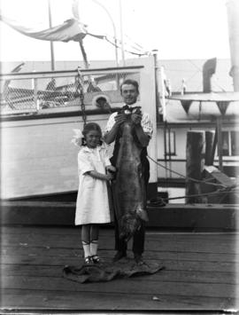 Mr. Gamage and daughter with fish on dock