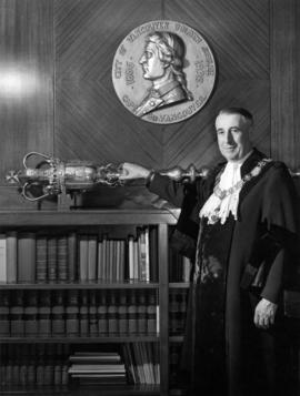 Portrait of Vancouver Mayor F.J. Hume standing beside city mace