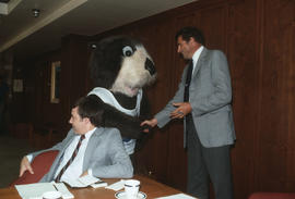 Tillicum shaking hands with a Centennial Committee member in meeting room at Vancouver City Hall