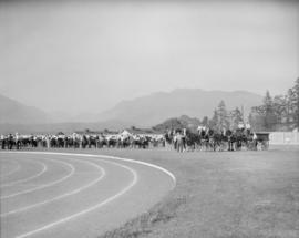 Canada Pacific Exhibition [Row of cattle on the field with four horse teams pulling wagons]