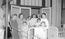 [Zazu Pitts with nurses and children in a hospital ward]