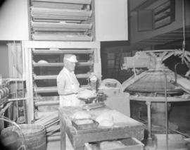 [Man operating a bakery machine]