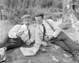 [Two men eating a picnic lunch]