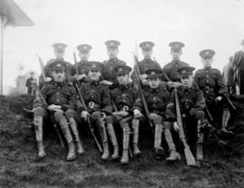 Group of ten high school army cadets seated on a hill