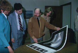 Toni Onley (centre) and group examine his Centennial Art Series print at Agency Press